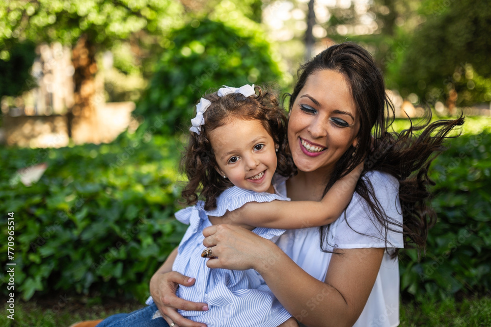 mother with little daughter hugging happily outdoors mother with little daughter hugging happily outdoors