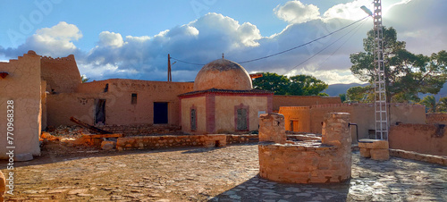 Old clay buildings among palm trees in the village Dechra Hamra, the town of El Kantara. Biskra. Algeria photo