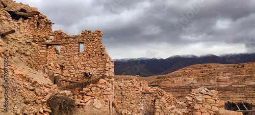 The balconies of Ghoufi, ancient Berber village, with stone and clay houses, carved into waterfalls in the rock, and the river which waters the oasis of palm trees and fruit trees. Batna. Algeria photo