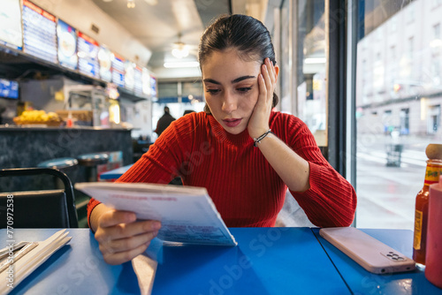 Woman reading the menu at a breakfast spot photo