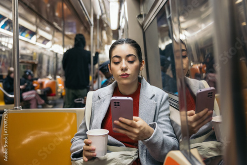 Woman using smartphone commuting on the subway