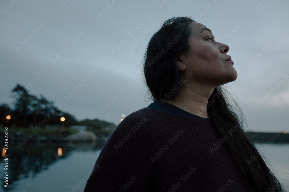 Serious women looking up - outside in blue evening dusk. Serious women looking up - outside in blue evening dusk.
