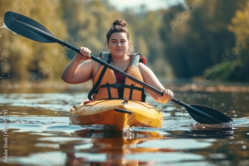 Cheerful plus-size young woman kayaking on a serene lake at sunset. © evgenia_lo
