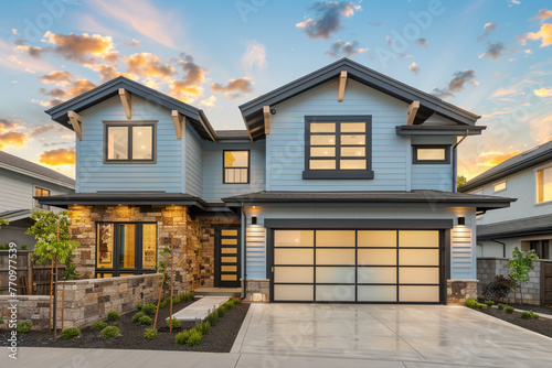 A luxurious modern residence with a two-car garage, framed by a soft powder blue siding and accented with natural stone wall trim for an elegant touch.