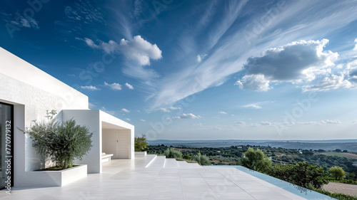 A white, avant-garde dwelling with sweeping views of the landscape and sky, embodying the spirit of innovation in modern living. photo