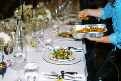 chef of catering company plating salads at dinner party photo
