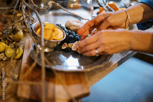 chef placing fresh figs on a pewter platter on an apperizer table photo