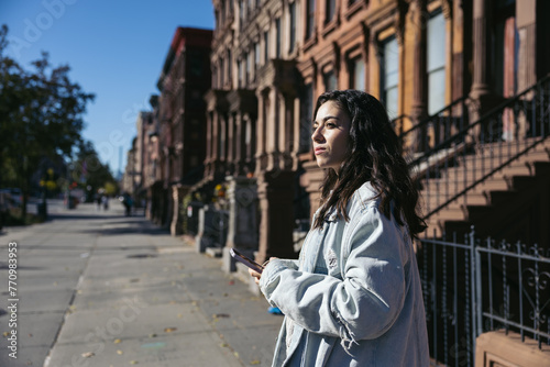 woman at the entrance of a residential building in Harlem, New York.
