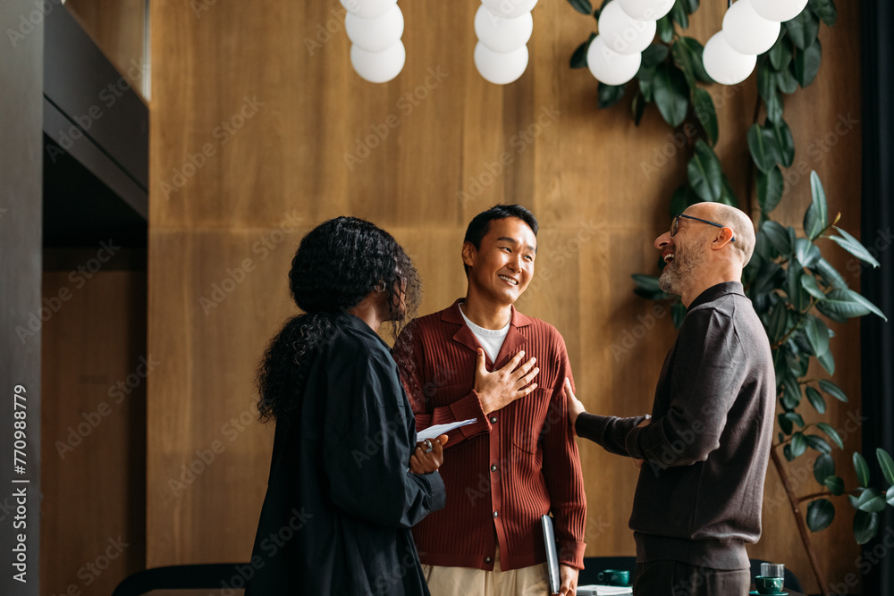 © Studio Firma/Stocksy - Colleagues standing in cafe