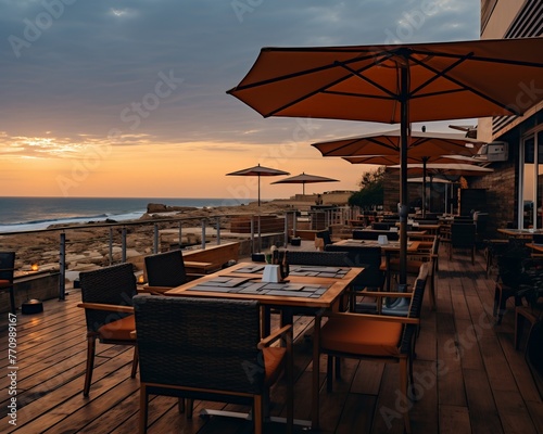 Alfresco dining area on a wooden deck with ocean views. Comfortable chairs and tables, large umbrellas for shade. Ideal for enjoying a meal while taking in the beautiful scenery.