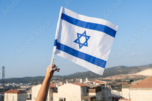 Child's Hand with Israeli Flag on Israel View Background. photo