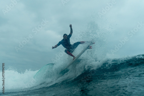 Professional surfer slide over the surface of turbulent waters photo