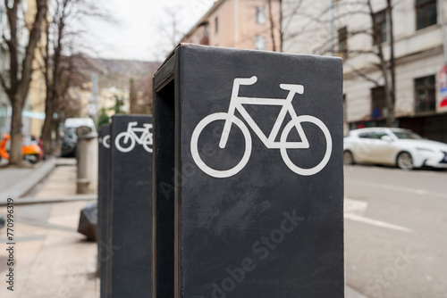 The row of bike park metal racks with bike icons, installed in the city. © Topuria Design