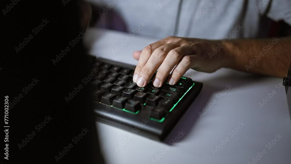 Close-up of a man's hands typing on a backlit mechanical keyboard in a dark room, highlighting technology and work. Close-up of a man's hands typing on a backlit mechanical keyboard in a dark room, highlighting technology and work.