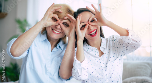 Tableau sur toile Emotional and excited laughing mother and daughter grimacing funny faces and sho