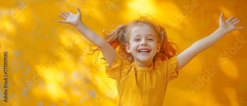 Yellow colored background with a funny young girl jumping on it