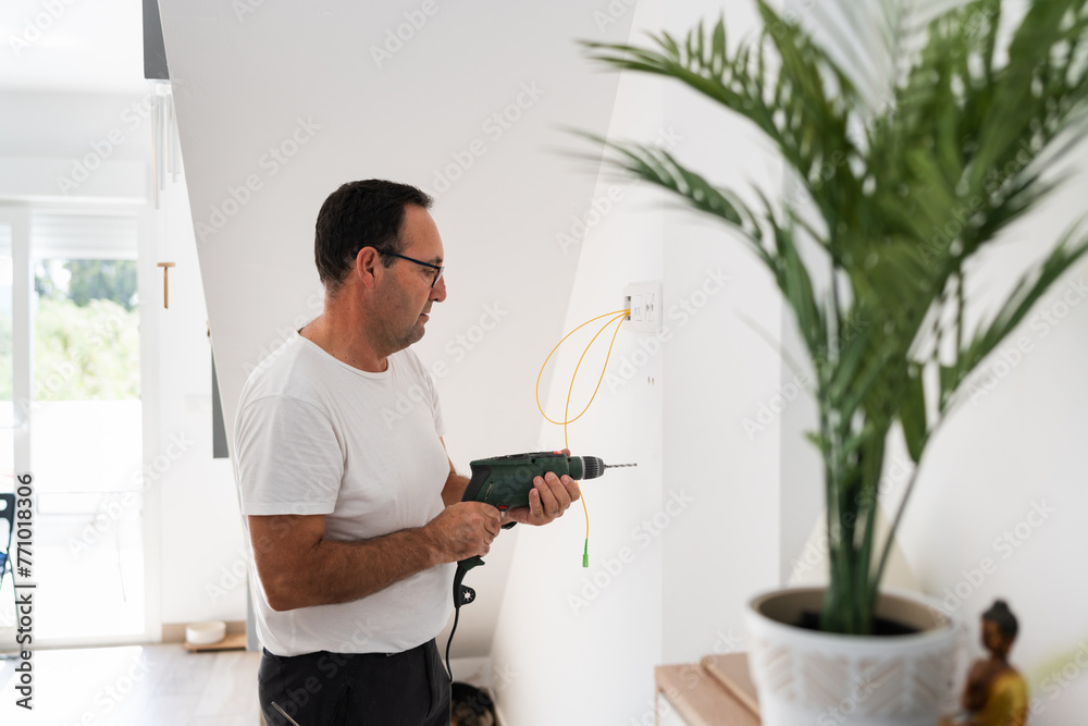 senior man drilling into a wall. senior man drilling into a wall.