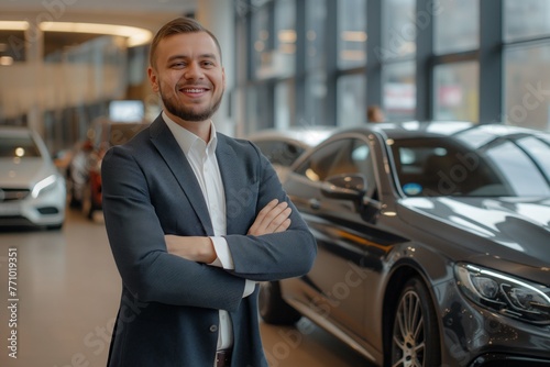 Confident Caucasian salesman in a suit smiling in a luxury car showroom © Darya Lavinskaya