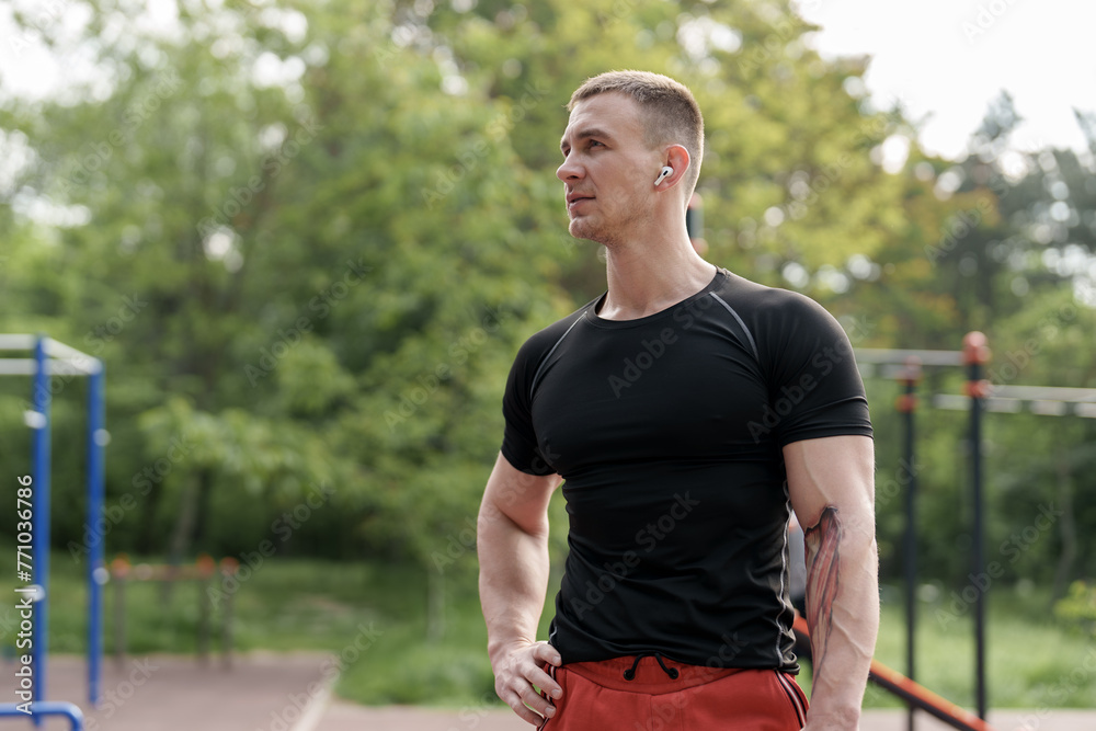 A physically fit man takes a break during his exercise routine at a local park. The image captures a sense of health, vitality, and the importance of physical fitness in natural surroundings.