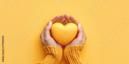 Top view of hands holding yellow heart in hands. Yellow Dat conceptual banner