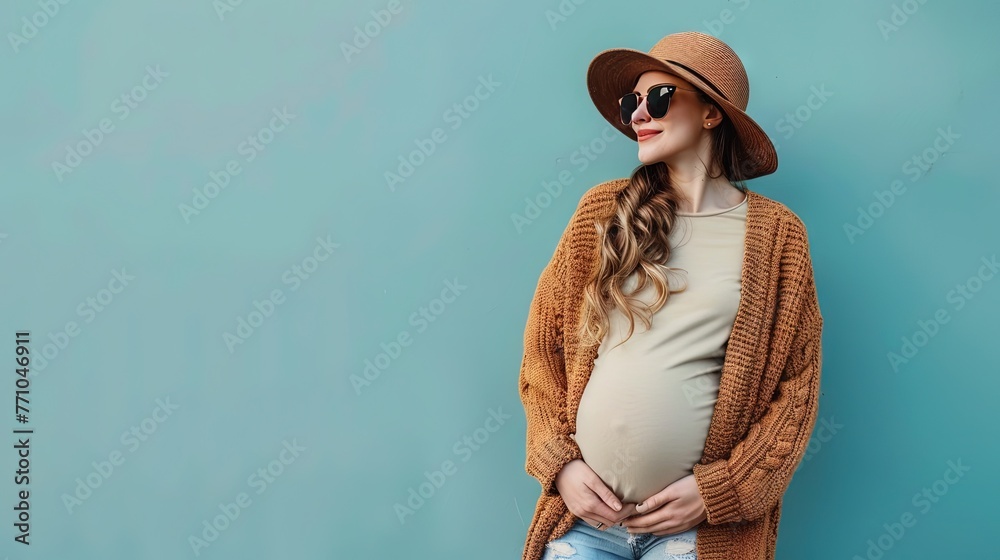 Pregnant woman with a belly bump enjoying life outdoors with loose-fitting and fashionable clothing - obrazy, fototapety, plakaty 