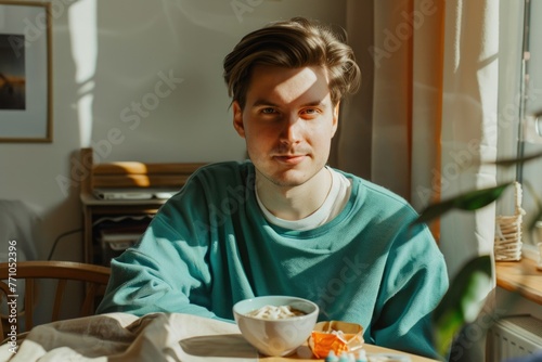 portrait of a man. student in the dorm. turquoise sweater. Breakfast in the kitchen photo