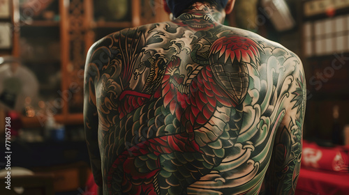 A stunning presentation of a man's back fully inked with a colorful hawk tattoo, illustrating traditional tattoo techniques