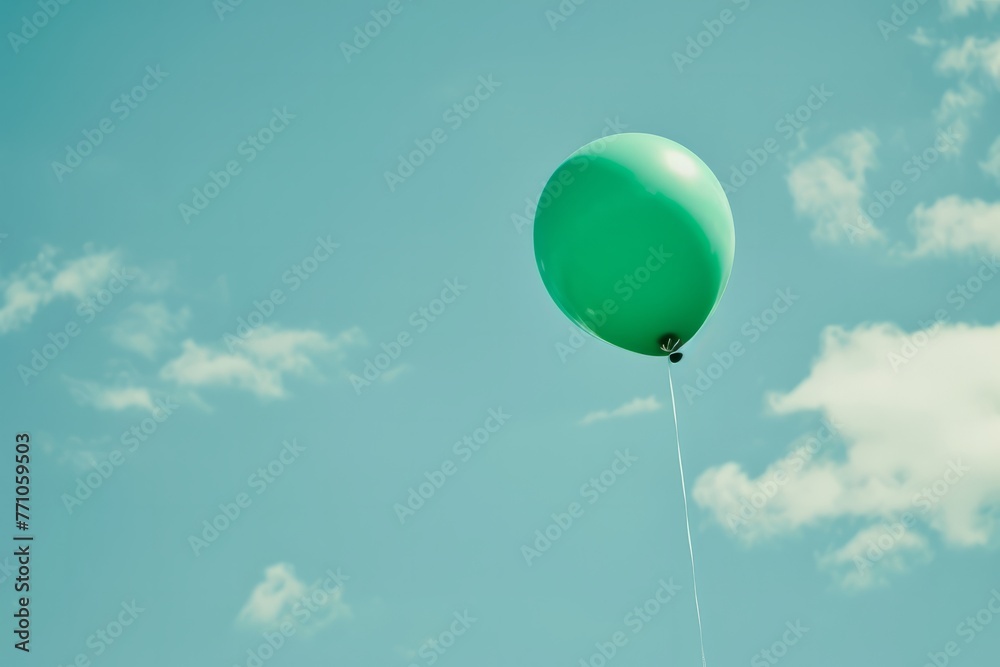 Obraz premium Vibrant green balloon representing mental health awareness floating against a soft blue sky creating a hopeful message of exploration and understanding