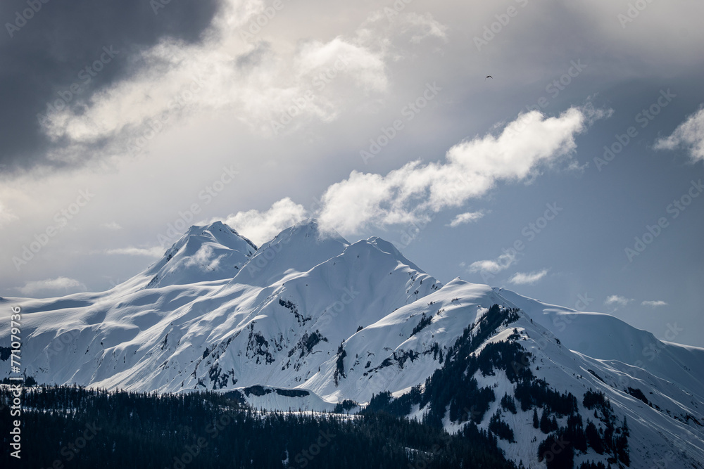 Dramatic snowy peaks emerging from storm clouds