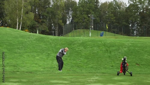 Woman Hits Ball with Golf Club and Misses, Then Hits. Golf is a Club-and-ball Sport Where Players Use Clubs to Hit a Ball Into Holes in as Few Strokes as Possible.