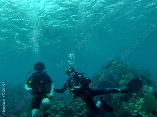 SCUBA divers on the reef in the Caribbean Sea, off the coast of Utila, Honduras