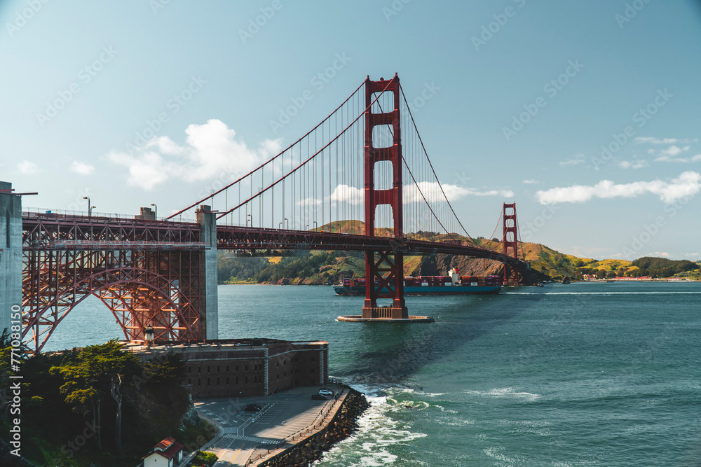 Fototapeta premium Cargo ship passing under the golden gate bridge