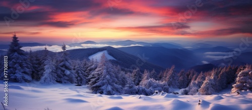 The atmosphere is painted in hues of orange and pink as the sun sets behind the snowy forest. A beautiful natural landscape with snowcovered trees and mountains in the background © AkuAku