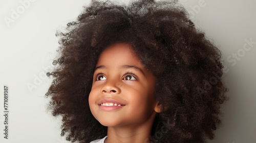 Cheerful child with curly hair smiling and looking away with a joyful expression