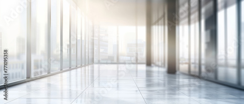 Golden light fills a spacious corridor with large windows overlooking the cityscape in this clean office setup