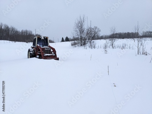 A Red Tractor on a snowy hill in the winter