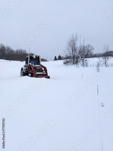 A Red Tractor on a snowy hill in the winter