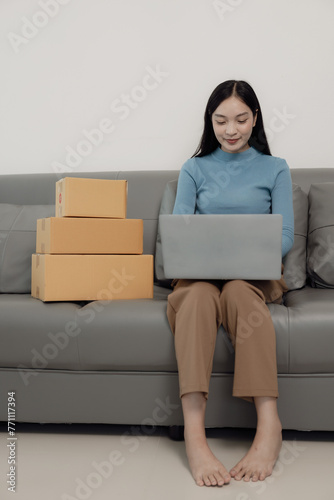 Free Download Postal parcel. Online sale. SME startup concept. Independent Asian woman small business entrepreneur wearing apron using laptop and box to order food online. SME business vertical image - GFXLoad
