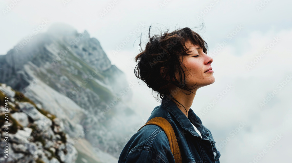 Side view of mid adult woman with eyes closed standing on mountain against cloudy sky