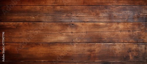 A close up shot of a brown wooden wall featuring a beautiful amber wood stain. The hardwood plank flooring showcases a unique pattern with a glossy varnish finish