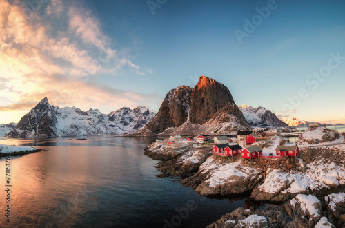 Red house fishing village with snow mountain at sunset