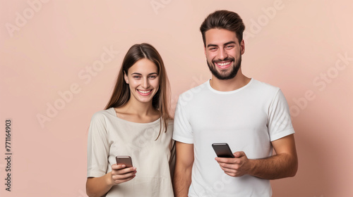 A man and a woman stand side by side, both holding up their cell phones, engrossed in the digital world at their fingertips, young smiling happy couple two friends family man woman wear casual clothes