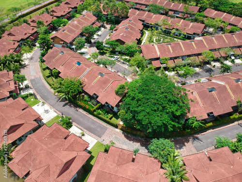 A view of a residential area with many houses and a tree in the middle