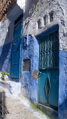Blue, metal door in a blue wall in the medina, in Chefchaouen, Morocco © Angela