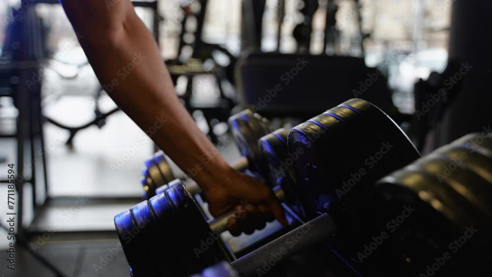 Close up of black man takes dumbbell in gym