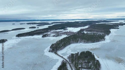Flying over a frozen lake and forest in the witner photo