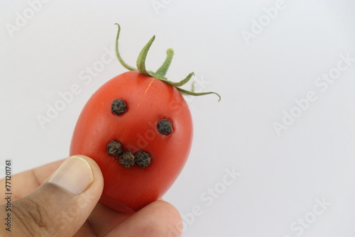 Fresh tomato with corns of pepper stuffed to look like a smiley that shows the concept of creativity and happiness