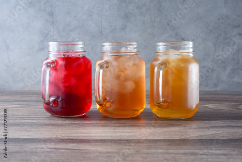 A view of three mason jars filled with iced teas.