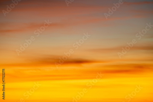 The dramatic colors of the sunset in the sky gradient from blue to orange. © EKKAPON