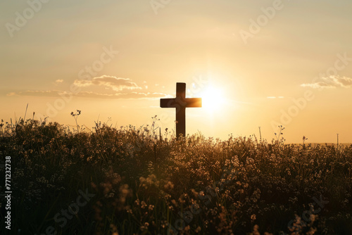 Christian cross silhouette against a sunrise meadow backdrop